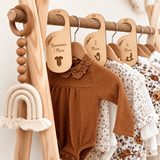 Séparateurs en bois naissance, 3 mois et 6 mois sur un portant de vêtements bébé